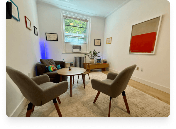 The consultation room. Soft chairs, natural light, a small table between.